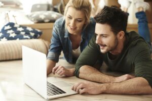 Couple reviewing dental practice information on laptop together at home.