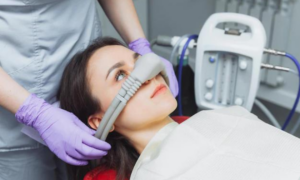 Dentist performing intraoral scan on patient during sedation dentistry treatment in Melissa.