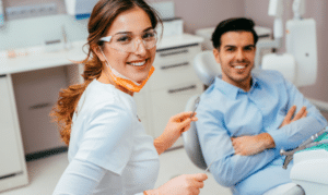Two smiling dental professionals in a modern treatment room in Melissa, TX.