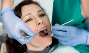 Dentist examining patient's teeth during emergency dental care appointment.