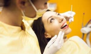 Patient receiving dental bonding treatment in dental chair with dentist in Melissa, TX.