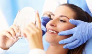 Woman smiling while dentist examines her teeth during dental consultation in Melissa, TX.