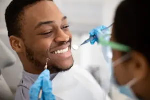 Dentist examining patient's teeth during dental checkup and treatment.