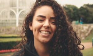 Smiling woman with curly brown hair in Melissa, TX dental office setting.