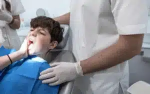 Young patient receiving dental examination in dentist's chair at Melissa, TX office.