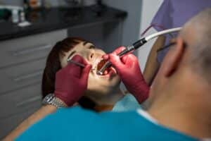 Dentist in Melissa performing dental treatment on patient with dental tools.